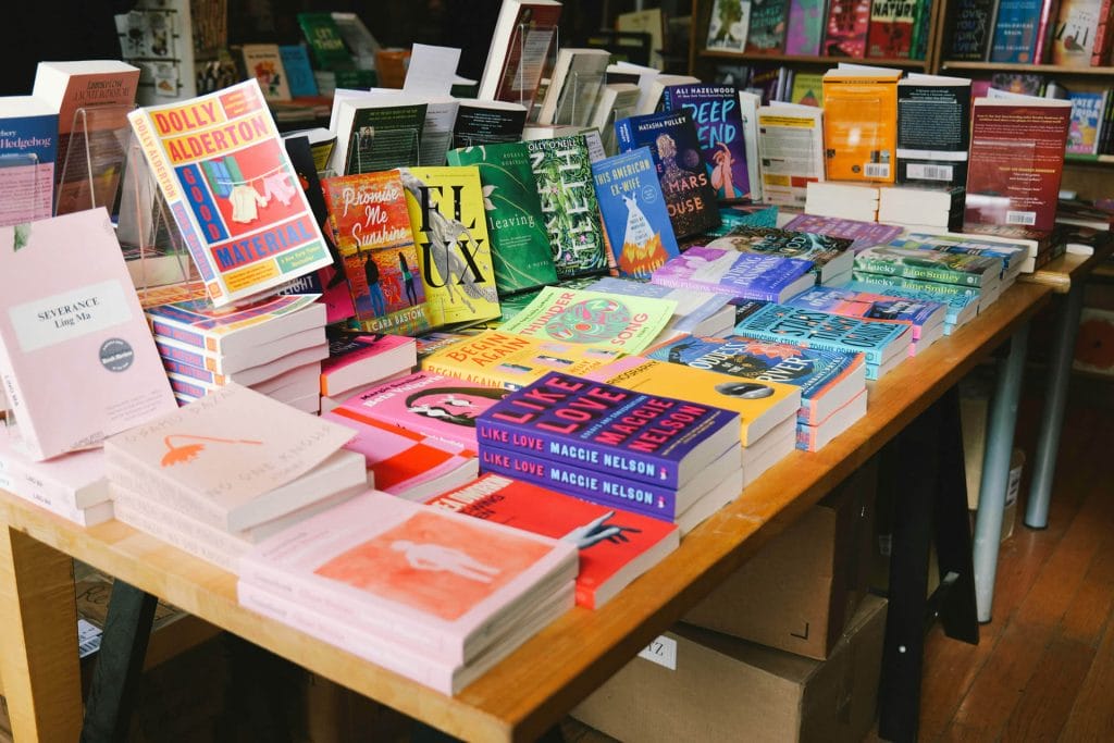 A table covered with books for sale.